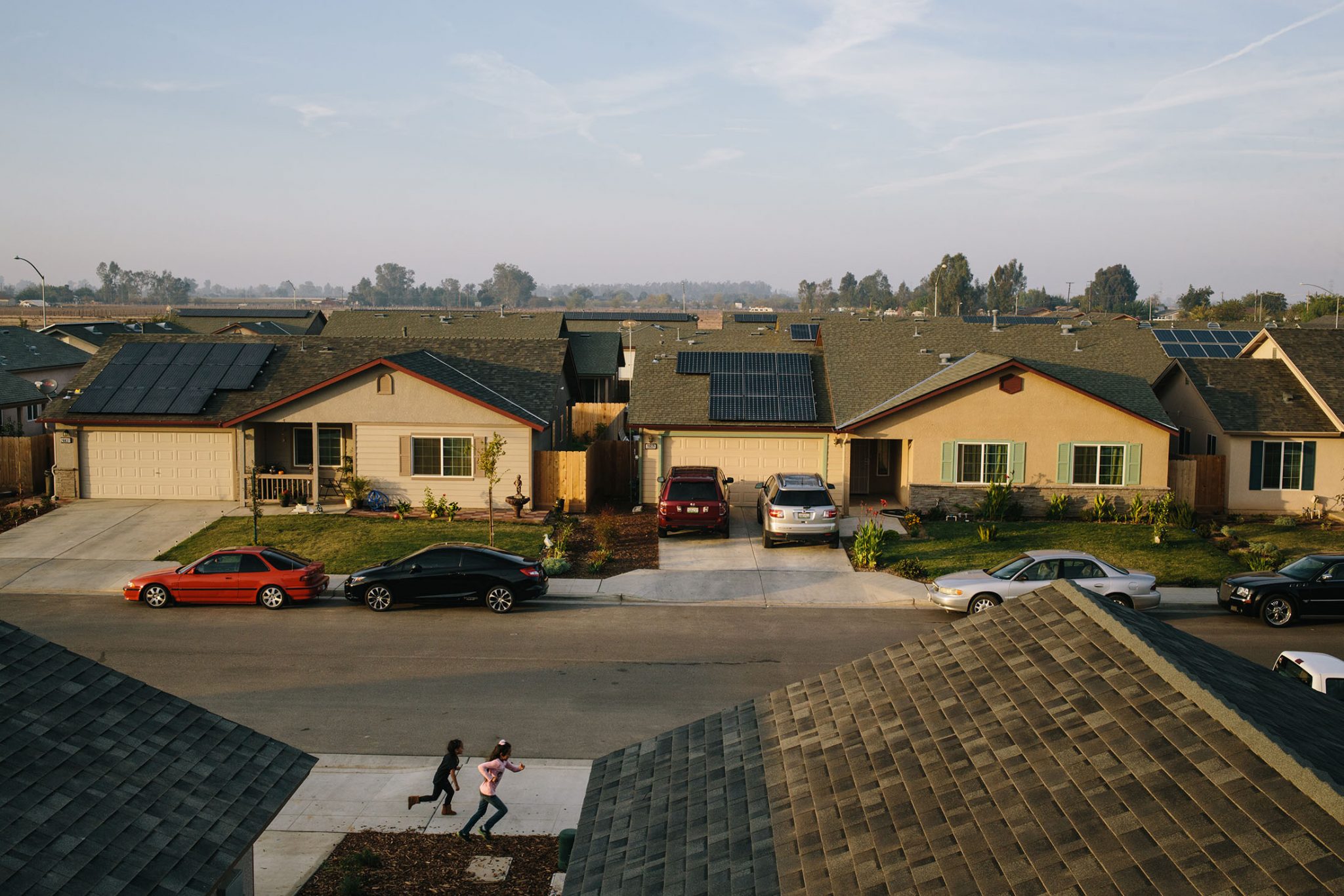 greenlining-environmental-equity Children play in their neighborhood in Madera, California where Grid Alternatives has retrofitted many of the houses with solar panels.
